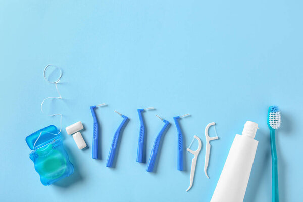 Toothbrushes for dental braces, floss and paste on color background