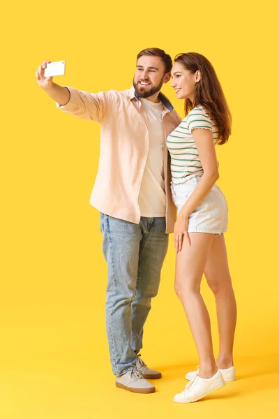 Pareja Joven Tomando Selfie Sobre Fondo Color — Foto de Stock