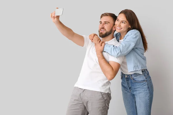 Junges Paar Macht Selfie Auf Hellem Hintergrund — Stockfoto