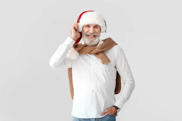 Älterer Mann Hört Weihnachtsmusik Auf Grauem Hintergrund — Stockfoto