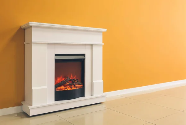 stock image Beautiful fireplace near color wall in room
