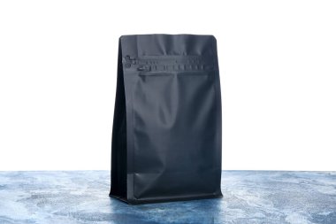 Masadaki boş kahve poşeti beyaz arka planda.