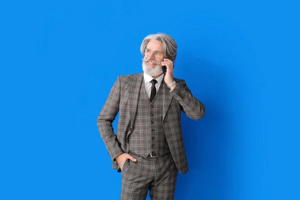 Porträt Eines Leitenden Geschäftsmannes Der Handy Auf Farbigem Hintergrund Spricht — Stockfoto