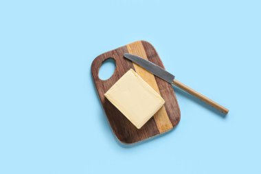 Renk arkaplanında taze tereyağı olan kesme tahtası