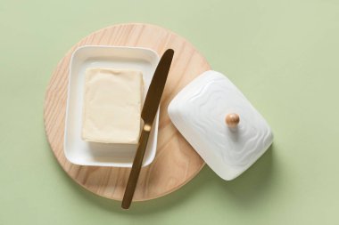 Renk arkaplanında taze tereyağı olan kesme tahtası