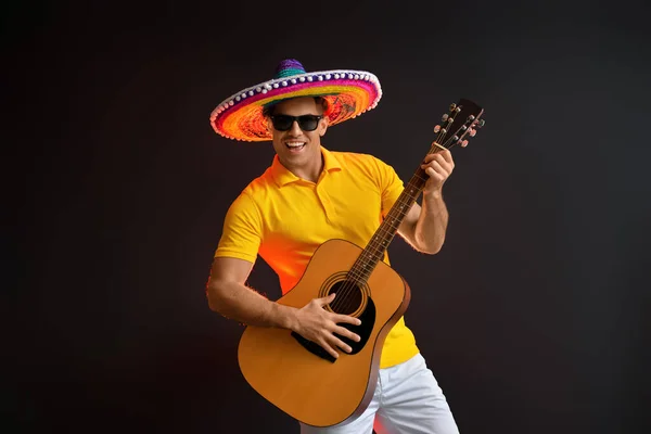 Przystojny Młody Człowiek Sombrero Kapeluszu Gitara Ciemnym Tle — Zdjęcie stockowe