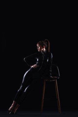 Güzel, modaya uygun genç bir kadın ve arka planda bir sandalye.