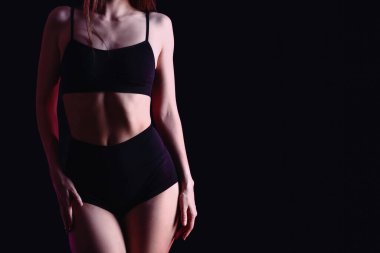 Siyah arka planda iç çamaşırlı güzel bir kadın.