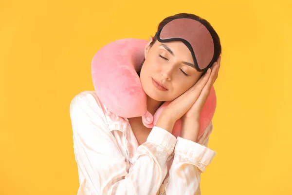 若いです女性の肖像でパジャマで睡眠マスクと首枕上の色の背景 — ストック写真