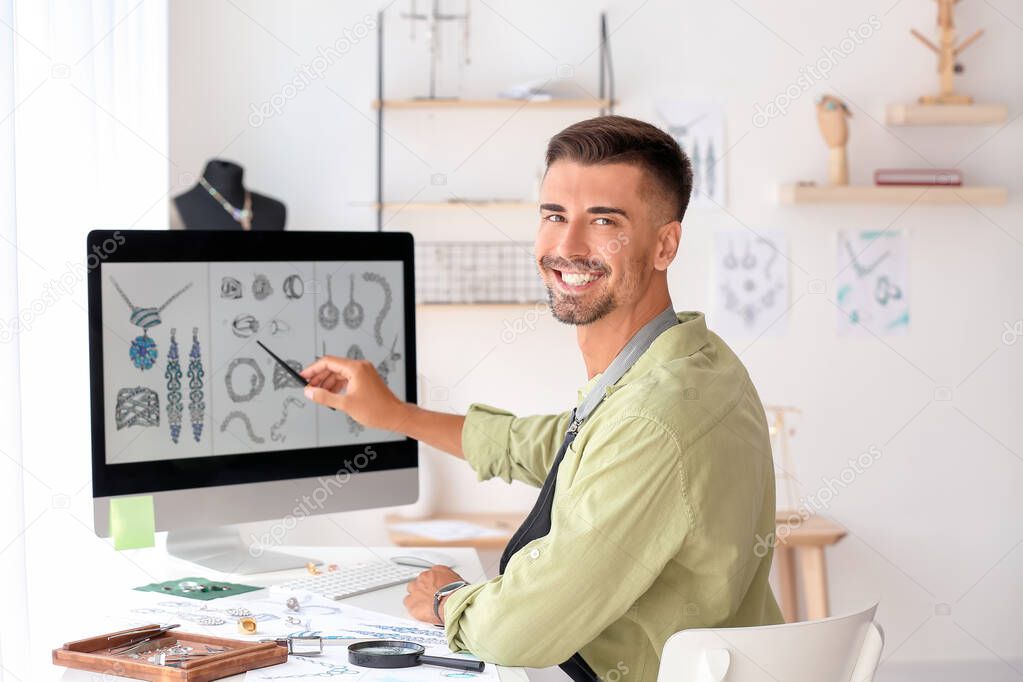 Male jewelry designer with sketches working in office