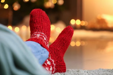 Evde şöminenin yanında sıcak çoraplı bir adam var. Isınma mevsimi kavramı