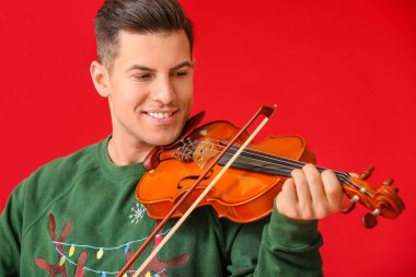 Genç adam arka planda keman çalıyor