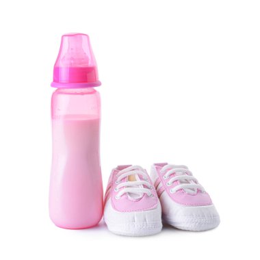 Bebek için bir şişe süt ve beyaz arka planda popolar.