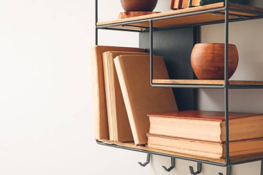 Beyaz duvarda kitap ve dekor olan raflar