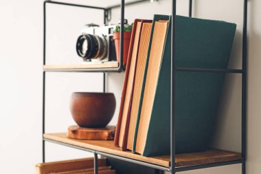 Beyaz duvarda kitap ve dekor olan raflar