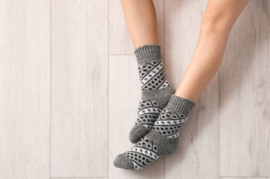 Ahşap arka planda çoraplı genç kadın bacakları.