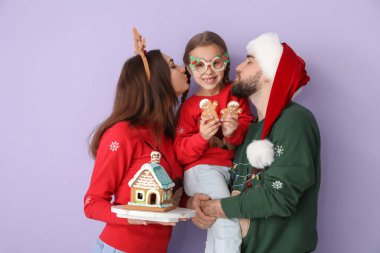 Renkli, zencefilli kurabiye evi olan mutlu bir aile. Noel kutlaması