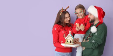 Renkli, zencefilli kurabiye evi olan mutlu bir aile. Noel kutlaması