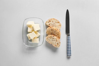 Taze tereyağlı kutu ve beyaz arka planda lezzetli ekmek.