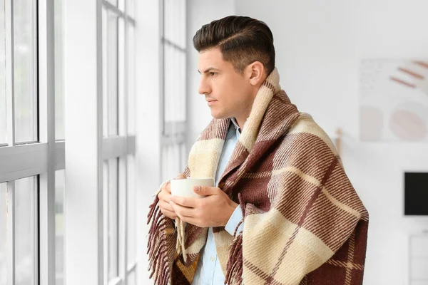暖かい演奏と自宅でお茶のカップを持つ若い男 暖房期の概念 — ストック写真