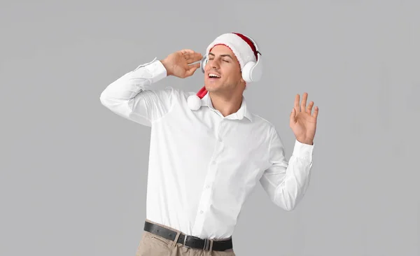 Young Man Listening Christmas Music Grey Background — Stock Photo, Image