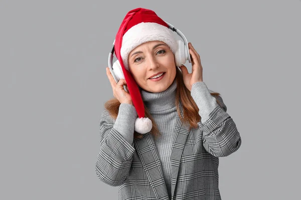 Mujer Madura Escuchando Música Navideña Sobre Fondo Gris —  Fotos de Stock