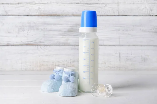 Bottle Milk Baby Pacifier Booties White Wooden Background — Stock Photo, Image