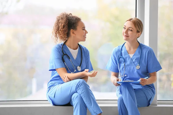 Vrouwelijke Artsen Zitten Vensterbank Kliniek — Stockfoto