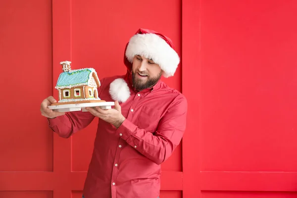 Glücklicher Junger Mann Mit Lebkuchenhaus Auf Farbigem Hintergrund Weihnachtsfeier — Stockfoto