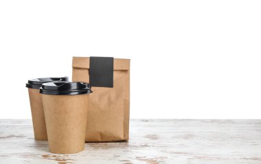 Kahveli ve fincanlı çanta beyaz arka planda.