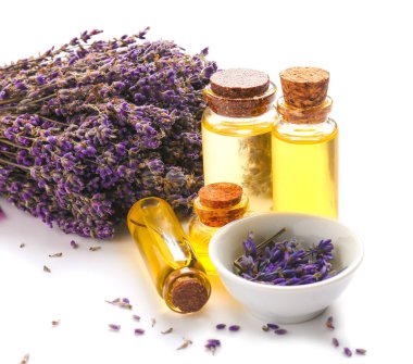 Beyaz zemin üzerinde lavanta yağı bulunan şişeler