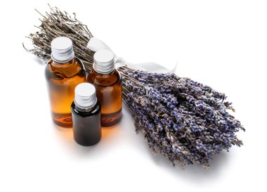 Beyaz zemin üzerinde lavanta yağı bulunan şişeler