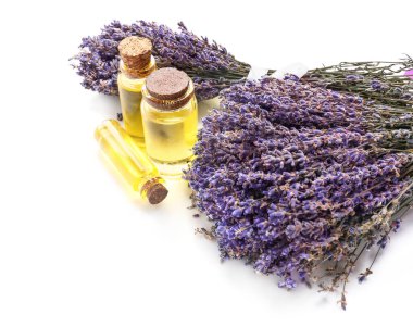 Beyaz zemin üzerinde lavanta yağı bulunan şişeler