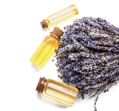 Beyaz zemin üzerinde lavanta yağı bulunan şişeler