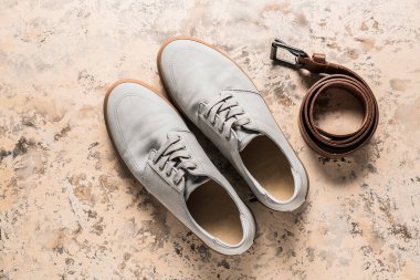 Şık ayakkabılar ve açık arkaplanda deri kemer.