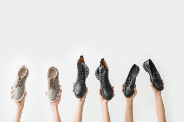 Beyaz arka planda şık ayakkabılı eller