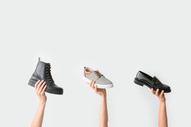 Beyaz arka planda şık ayakkabılı eller