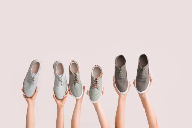 Beyaz arka planda şık ayakkabılı eller