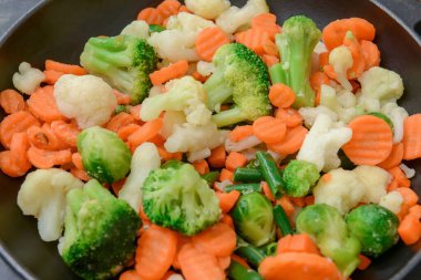 Donmuş sebzeler tavada, yakın plan.