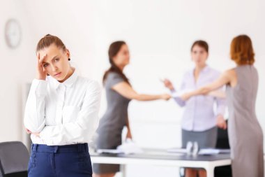 Ofiste başı ağrıyan ve gürültücü insanlar olan stresli bir kadın.