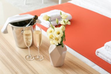 Balayı odasındaki masada şampanya ve buz kovası.