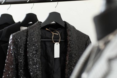 Askılarda giysi ve boş kağıt etiket