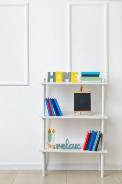 Odanın içinde kitap ve dekor olan raf ünitesi