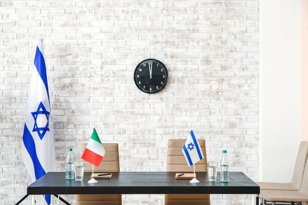 Flags of Israel and Italy on table in embassy office