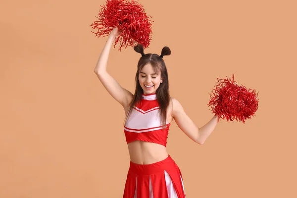 Beautiful young cheerleader on color background