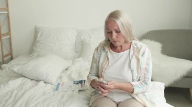 Evde telefonla konuşan stresli olgun bir kadın.