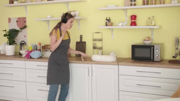 Young Woman Listening Music While Cleaning Kitchen — Stock Video