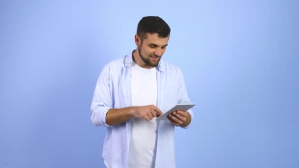 Gelukkig Jongeman Met Tablet Computer Vieren Zijn Succes Kleur Achtergrond — Stockvideo