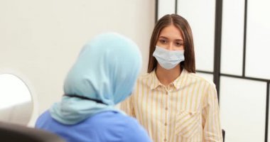 Genç bir kadın klinikteki Müslüman doktoru ziyaret ediyor.