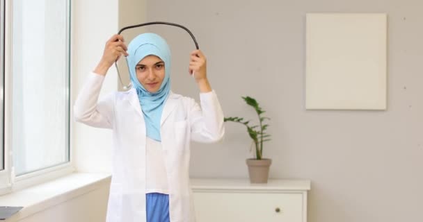 Kliniğin Penceresinin Yanında Steteskobu Olan Kadın Müslüman Doktor — Stok video